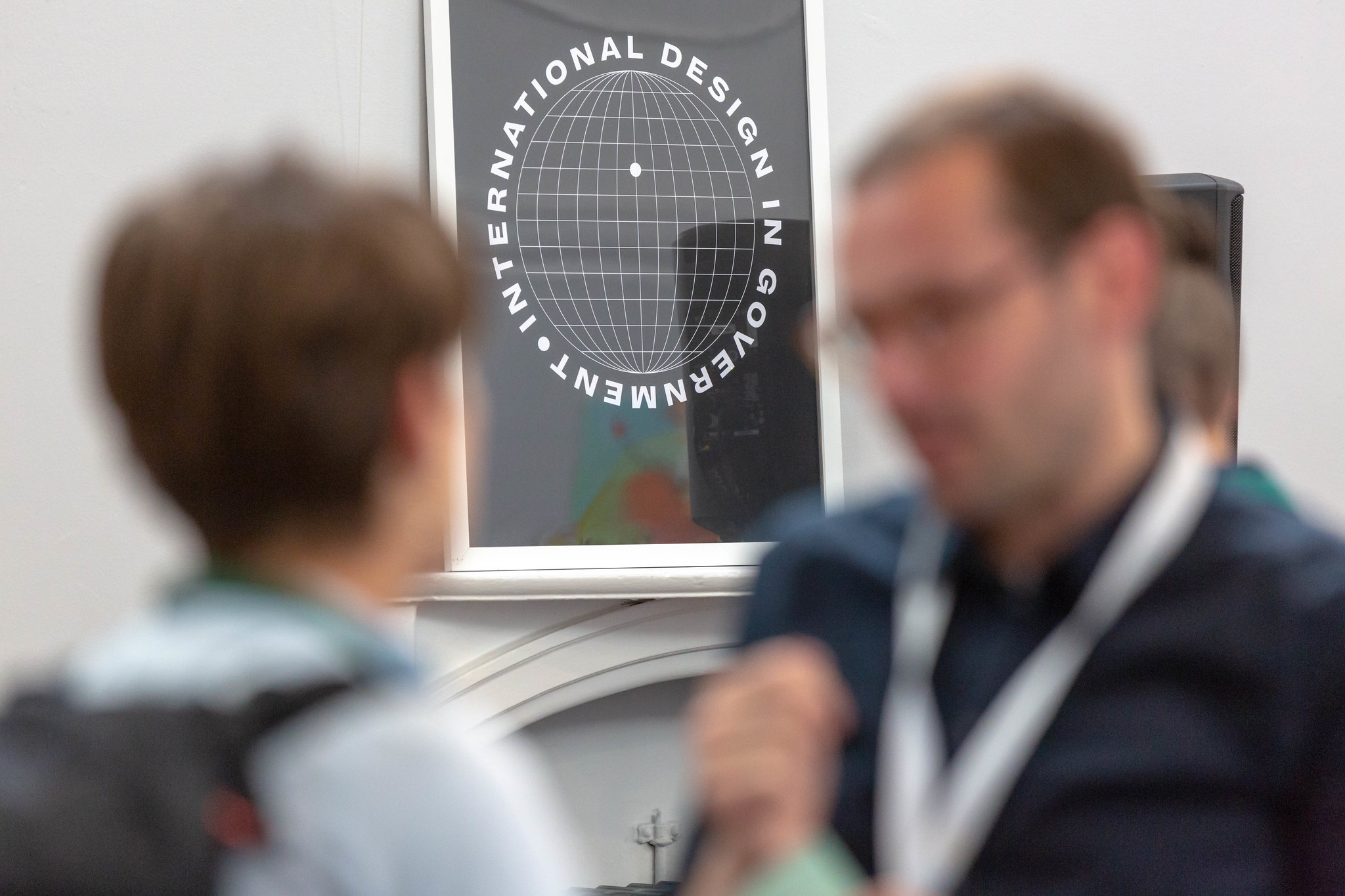 People at the London conference with a poster of the event in the background.